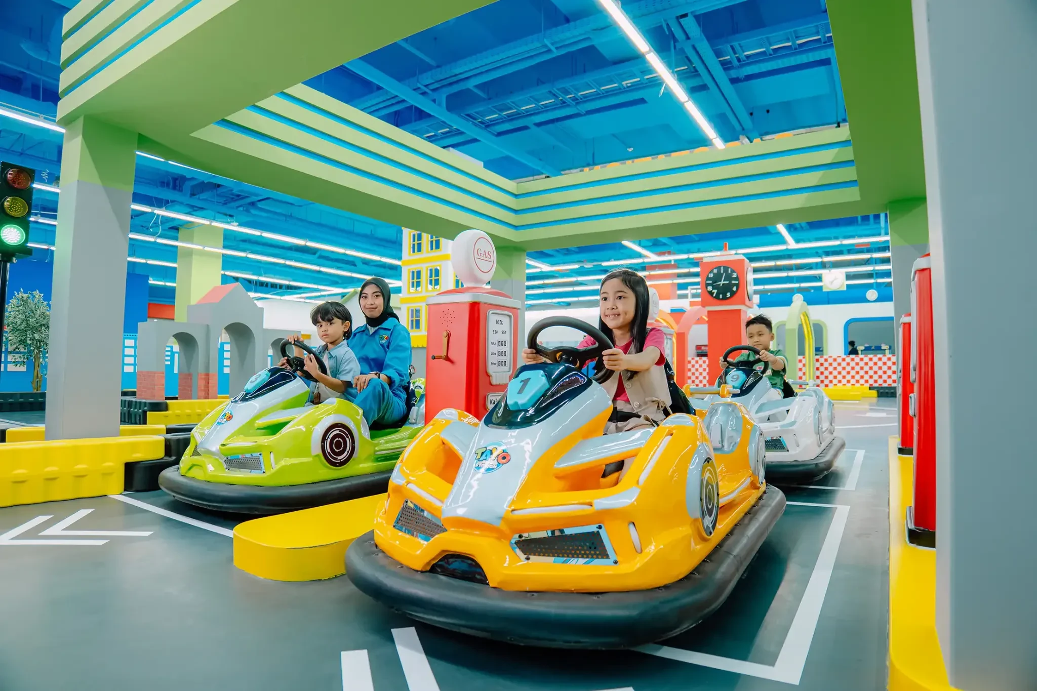 Children driving colourful Tayo-themed ride-on cars inside Tayo Station